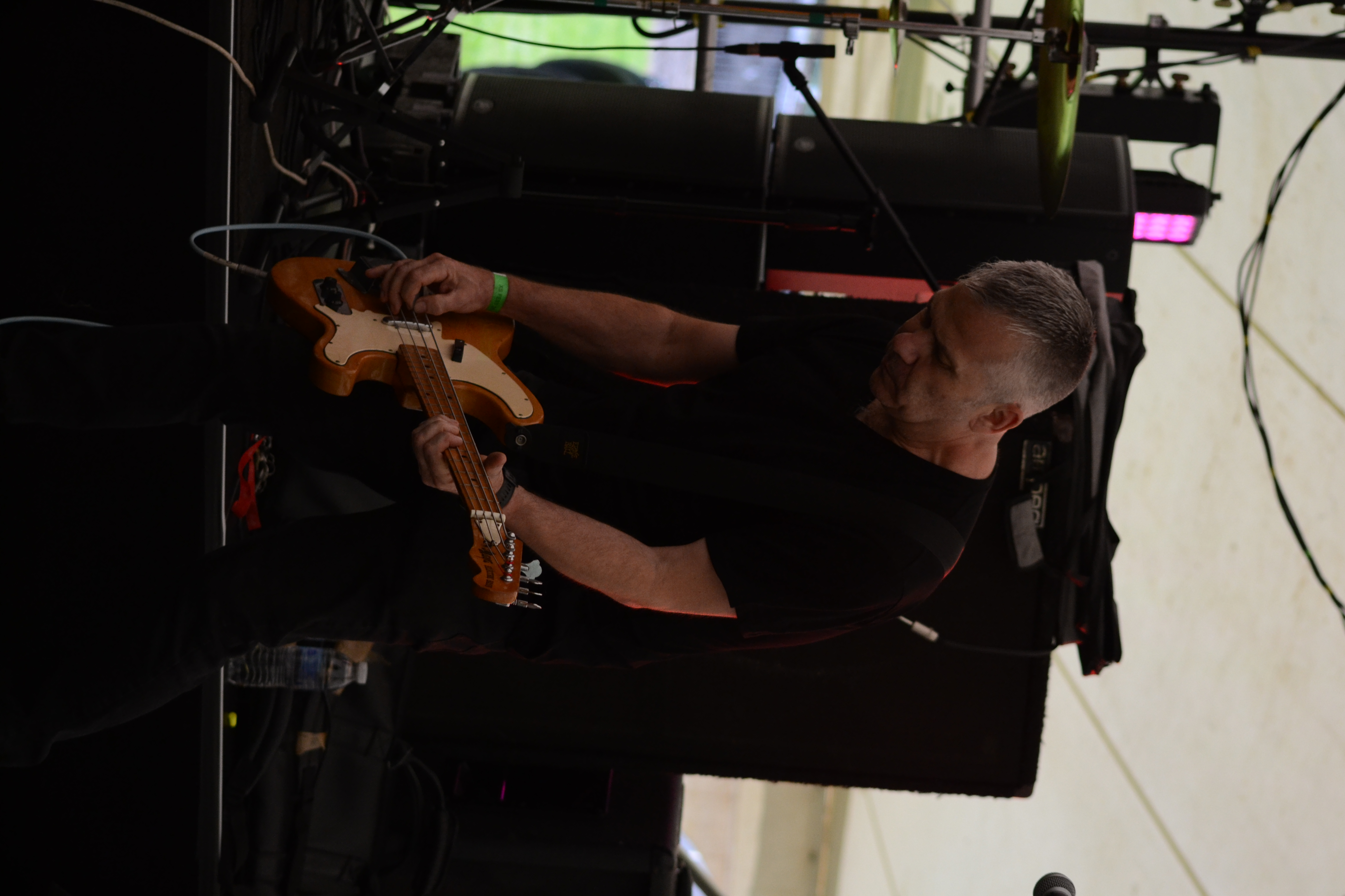 Side view of guitarist-vocalist in cap and sunglasses singing while playing
